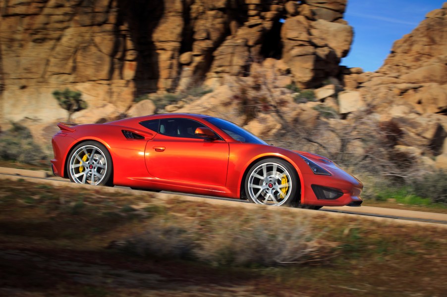 Red Saleen S1 sports car driving down the road.