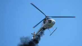 A small rotary-wing aircraft billows smoke as it fights becoming another helicopter crash statistic.