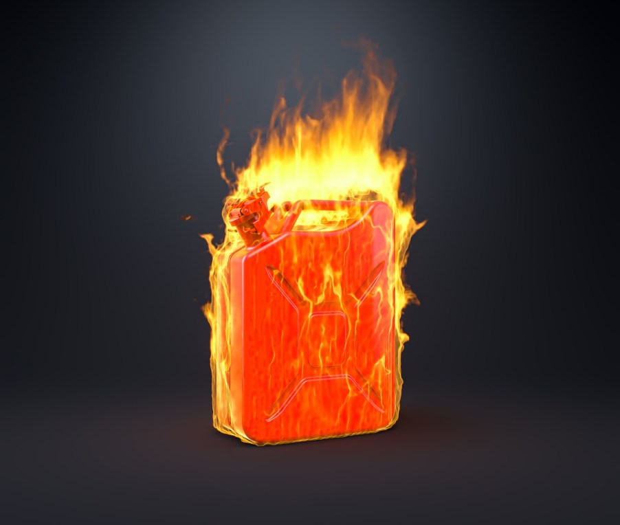 Red gasoline can on fire and covered in flames, on a black background.