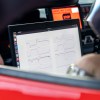 A technician looks over the screen readout in the cockpit of an autonomous Toyota Supra race car