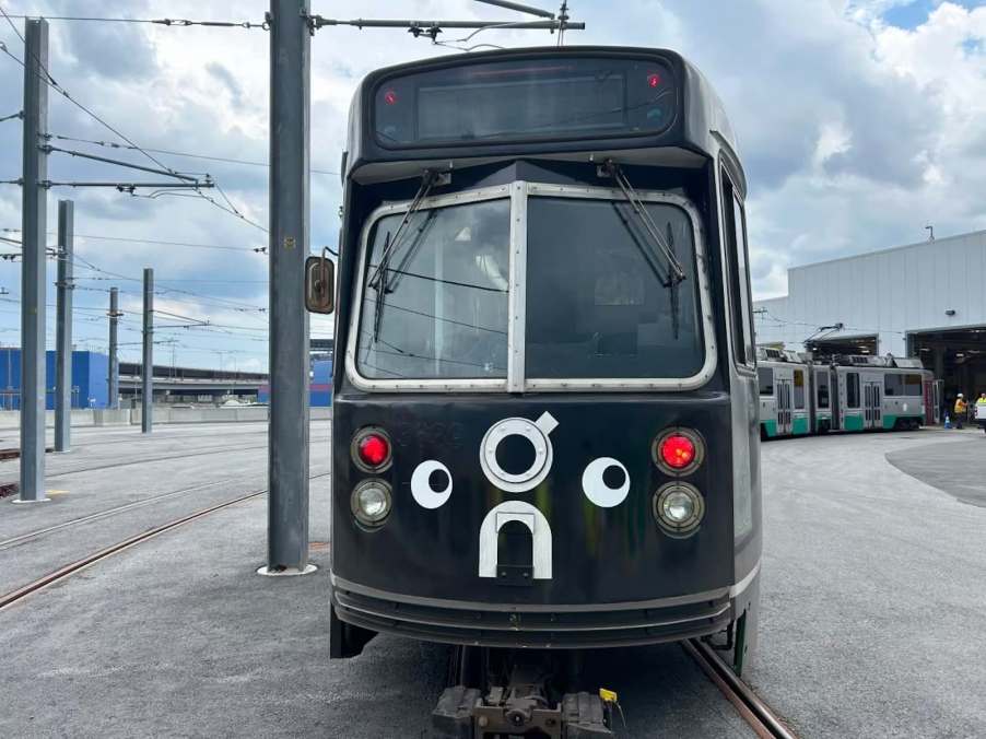 Black train in Boston with goofy googly eyes painted on the fornt.