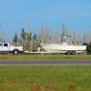 A white truck towing a trailer with a boat.