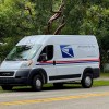 A USPS mail van parked on the side of the road