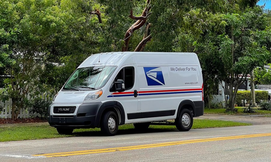 A USPS mail van parked on the side of the road