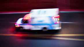 An ambulance speeding on a road at night in left profile view on May 31, 2024, one woman's iPhone called 911 after she was hit head-on