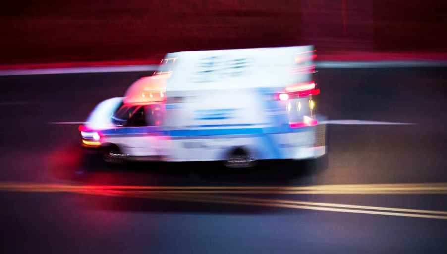 An ambulance speeding on a road at night in left profile view on May 31, 2024, one woman's iPhone called 911 after she was hit head-on