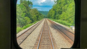 Railroad tracks view from rail car the Great American Rail-Trail is working to convert and connect thousands of miles of pathway across the country