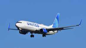 A United Airlines plane flying in full left front angle view in 1990 a man purchased a lifetime flight pass from the airline and has flown more than 24 million miles with United