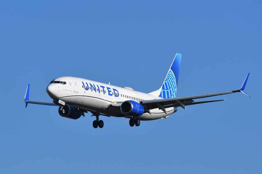 A United Airlines plane flying in full left front angle view in 1990 a man purchased a lifetime flight pass from the airline and has flown more than 24 million miles with United