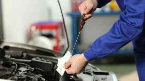 Mechanic checks oil as part of a used car inspection