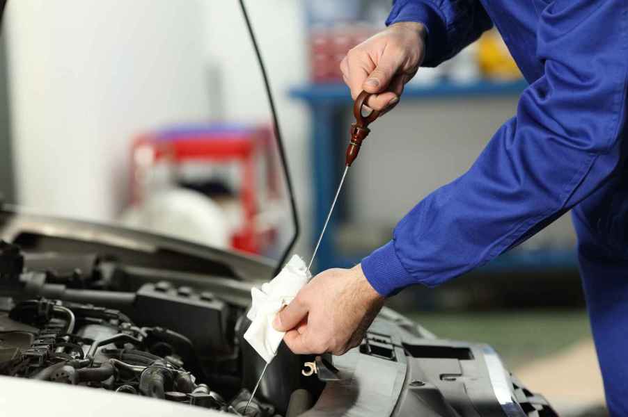 Mechanic checks oil as part of a used car inspection