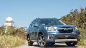 Blue 2018 Subaru Forester parked on a sandy trail.