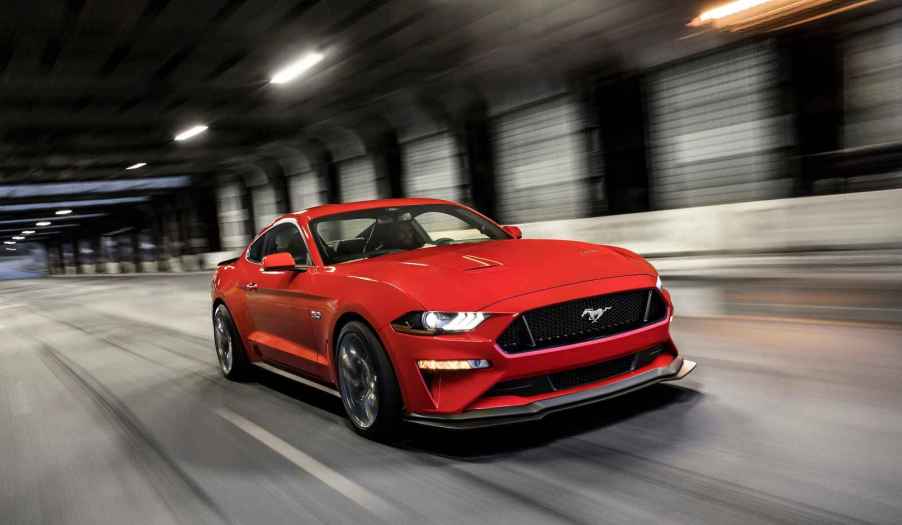 A red 2019 Ford Mustang driving fast in a tunnel