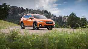 An orange 2020 Subaru Crosstrek parked in a National Park-like setting in right front angle view midground position