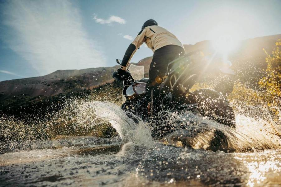 A 2024 Harley-Davidson Pan America 1250 Special ADV motorcycle kicks up water.