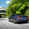 A Ford Mustang EcoBoost drives on a highway access road at speed.