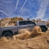 2024 Chevrolet Silverado HD ZR2pickup truck in full right profile view kicking up dust Chevrolet is owned by GM which is beating Ford for overall truck sales in 2024