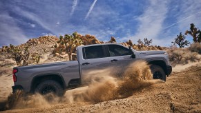 2024 Chevrolet Silverado HD ZR2pickup truck in full right profile view kicking up dust Chevrolet is owned by GM which is beating Ford for overall truck sales in 2024