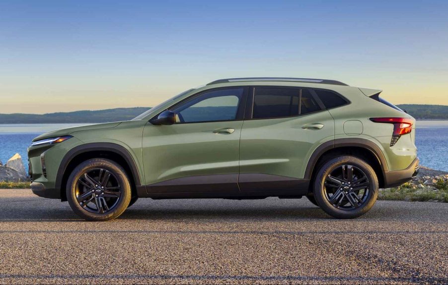 A green 2024 Chevrolet Trax parked in full left profile view in front of water