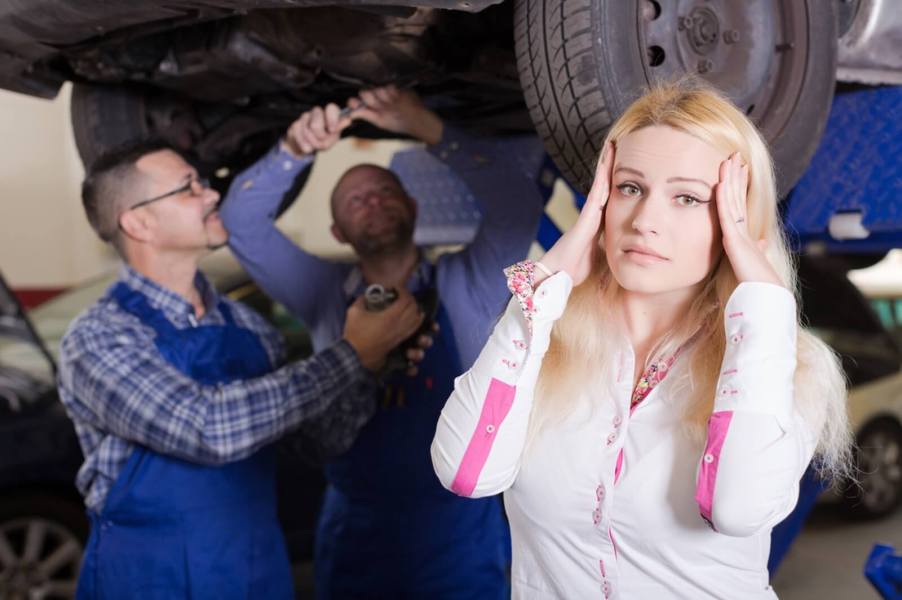 A driver is frustrated by a mechanic and their partner at an auto shop.