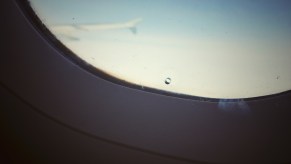 Closeup of the "bleed hole" in the inner layer of a commercial airplane's window.