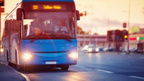 Blue city bus in front of the sunset.