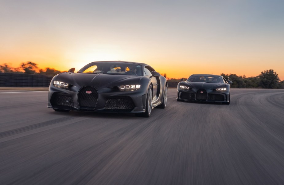 Two black Bugatti hypercars drive on a track