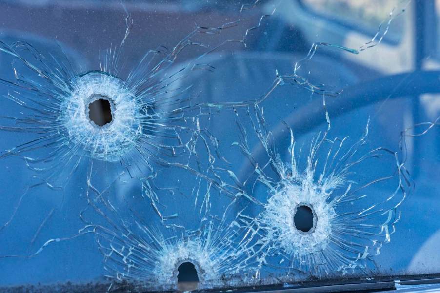 A car windshield with three bullet holes in the glass