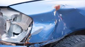 The smashed windshield and fender of a vehicle after a car crash.