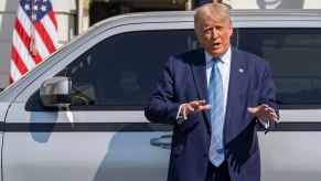 President Donald Trump gives a speech standing next to an electric truck.