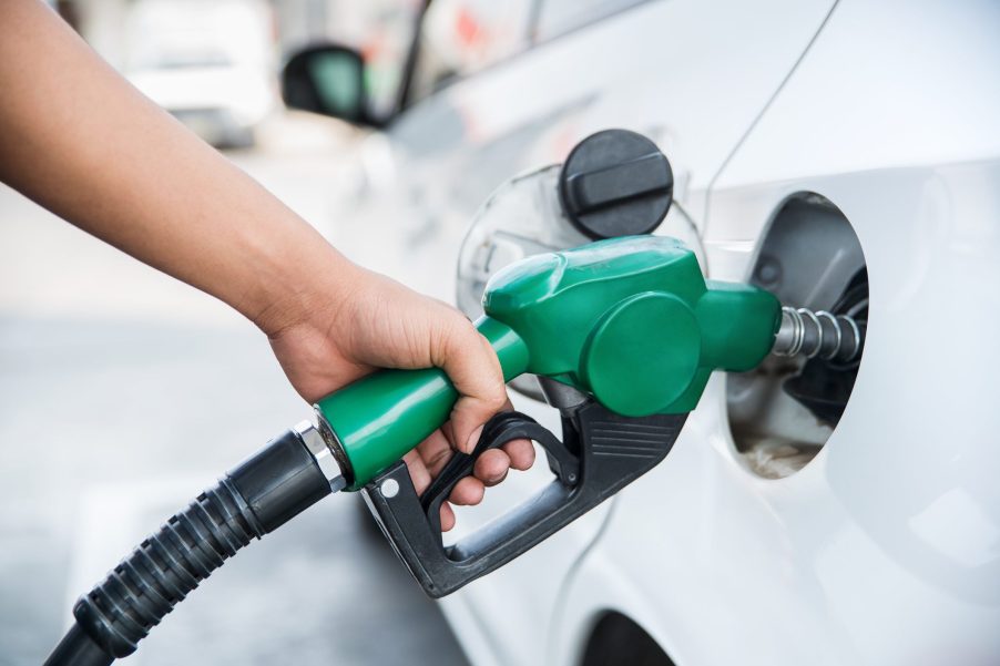 Driver fuels up their luxury car at a gas station.