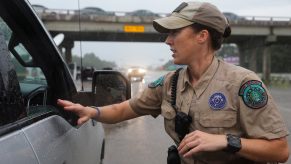 A Texas game warden talks to a driver of a pickup truck stopped on the highway.