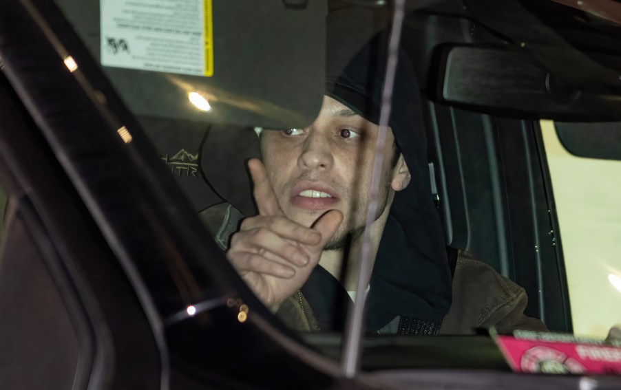 Pete Davidson driving a car at night