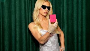 Paris Hilton stands with a Motorola phone at an event.