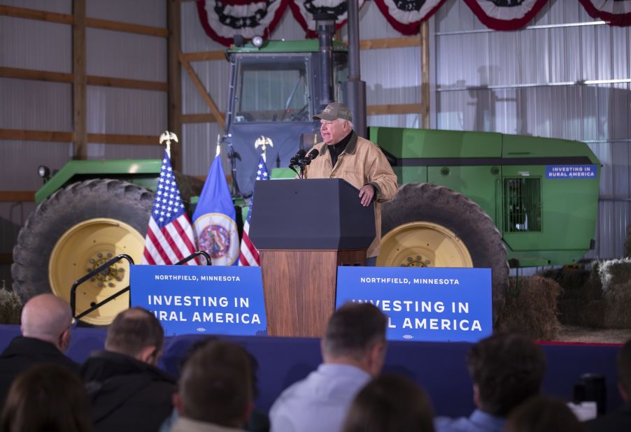 Governor Tim Walz stands in front of a John Deere tractor at President Joe Biden's Investing in Rural America tour