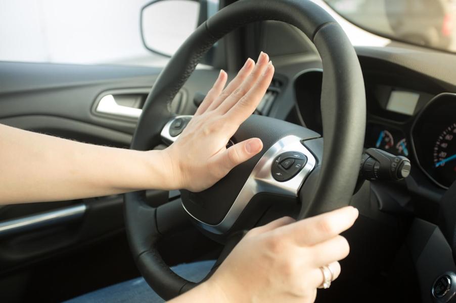 An angry driver honking their car's horn excessively.