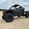 A new Polaris RZR Pro R in black on the beach after driving off-road.