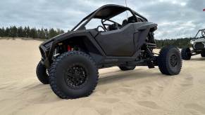 A new Polaris RZR Pro R in black on the beach after driving off-road.