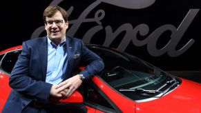 The CEO of Ford leans against a red Fiesta.