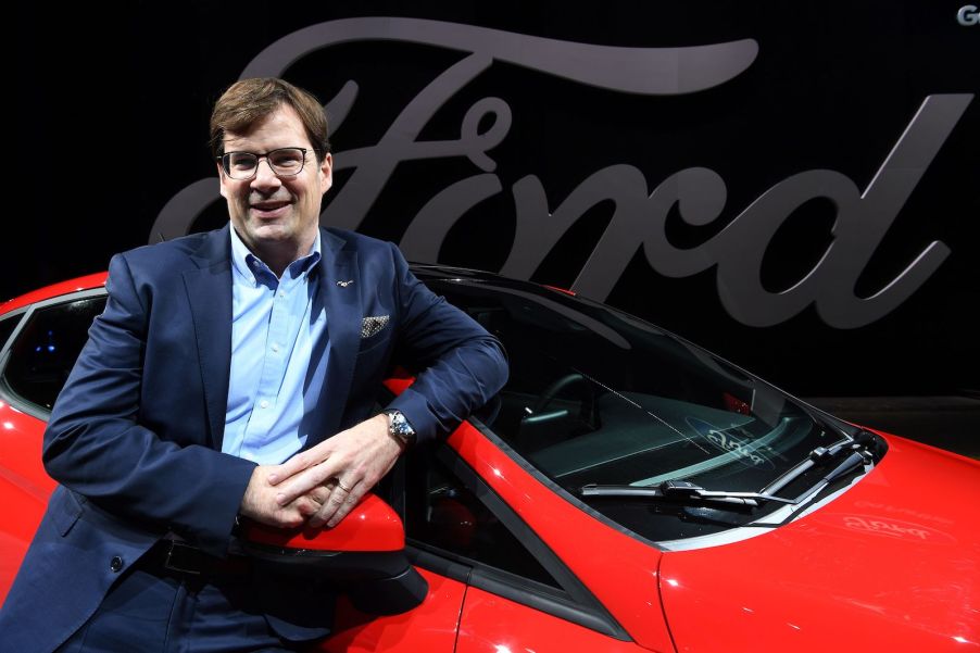 The CEO of Ford leans against a red Fiesta.