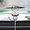 The Mercedes hood emblem on a vintage car.