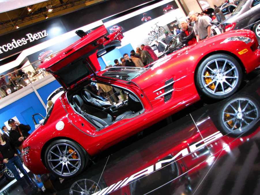 Red Mercedes gullwing SLS coupe at an auto show.