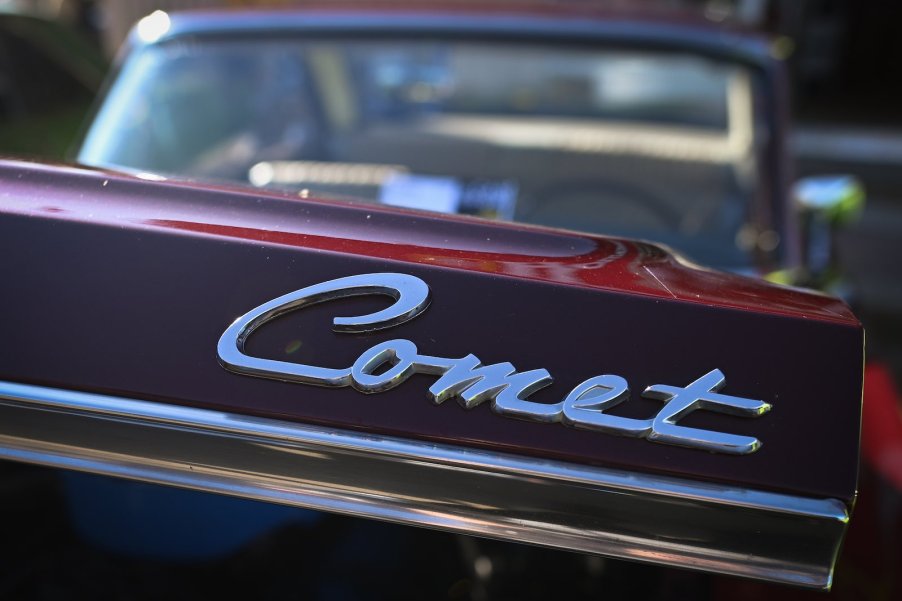 The "Comet" badge on the trunk of a Mercury Comet Caliente at a car show.