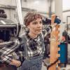 Young Millennnial or Gen Z mechanic DIYer stands in a garage auto shop.