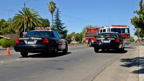 Police officers pull over with a fire truck at an emergency scene.