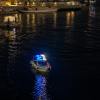 A police boat lights up the waters in a harbor.