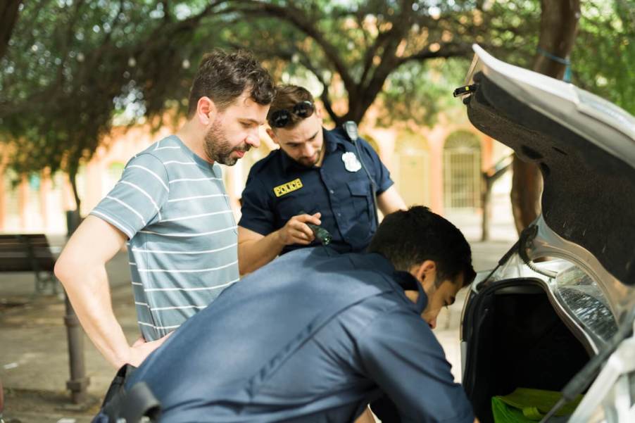 Police officers find a illegal items and gun in the car as they search a driver's vehicle.