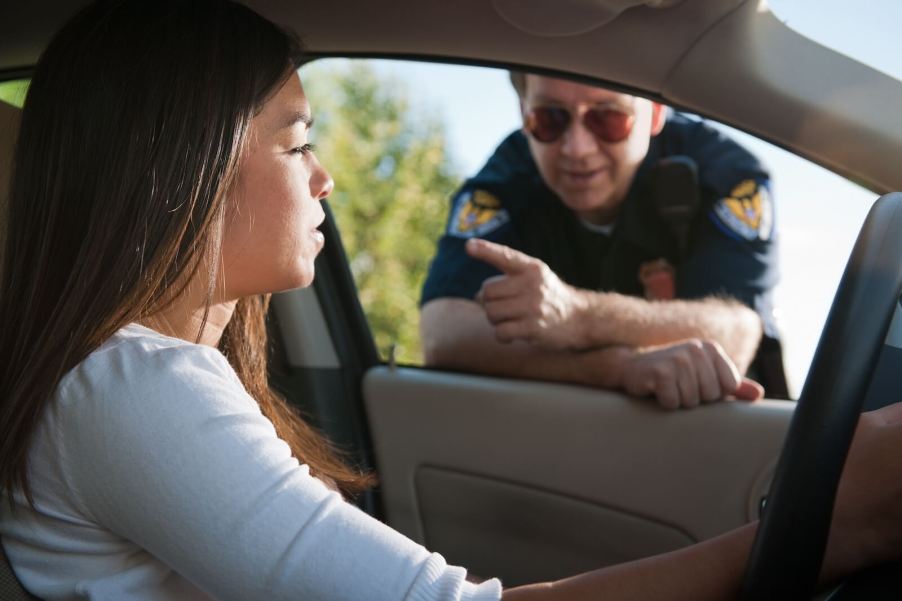 A police officer prepares to write a speeding ticket for a driver.