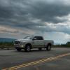 Heavy-duty Ram pickup truck with a Cummins engine parked on a mountain road, dark clouds visible in the background.