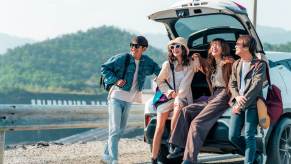 A group of friends smile during a safe stop on a road trip.